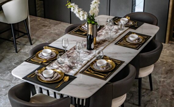Fine dining set up with full cutlery glassware and charger plate on a marble table